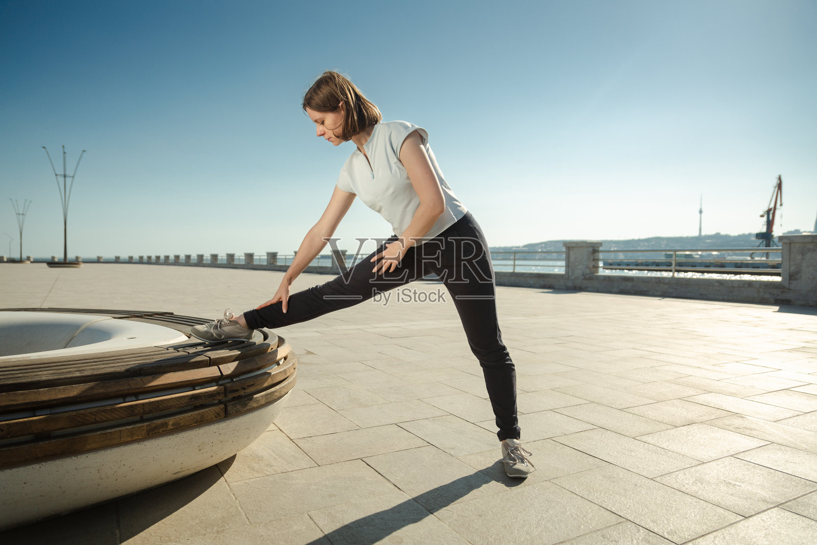 年轻女子在室外用长凳做运动照片摄影图片