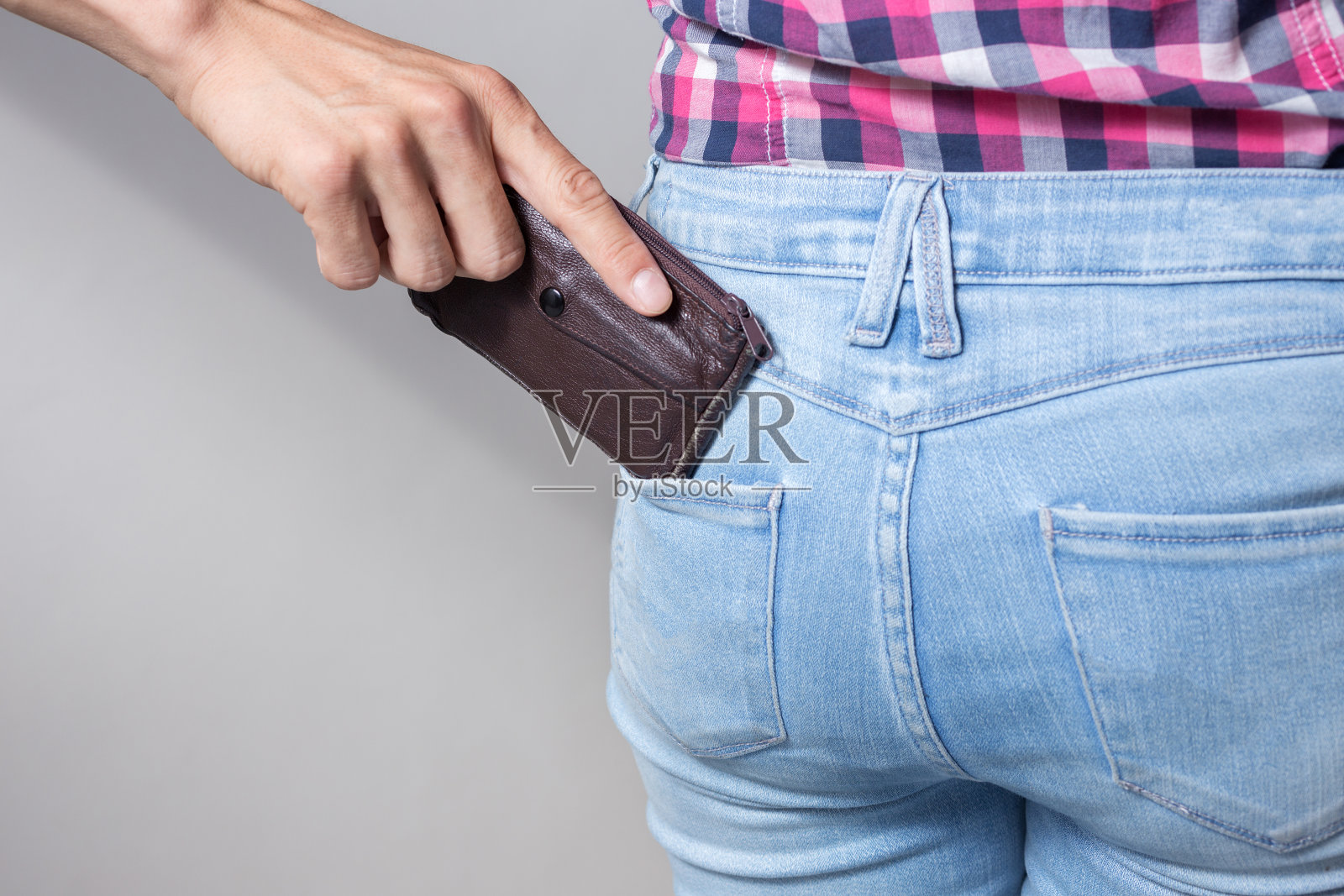 3 .扒手从裤子后面的口袋里掏出偷钱包的时候，镜头拉近了照片摄影图片