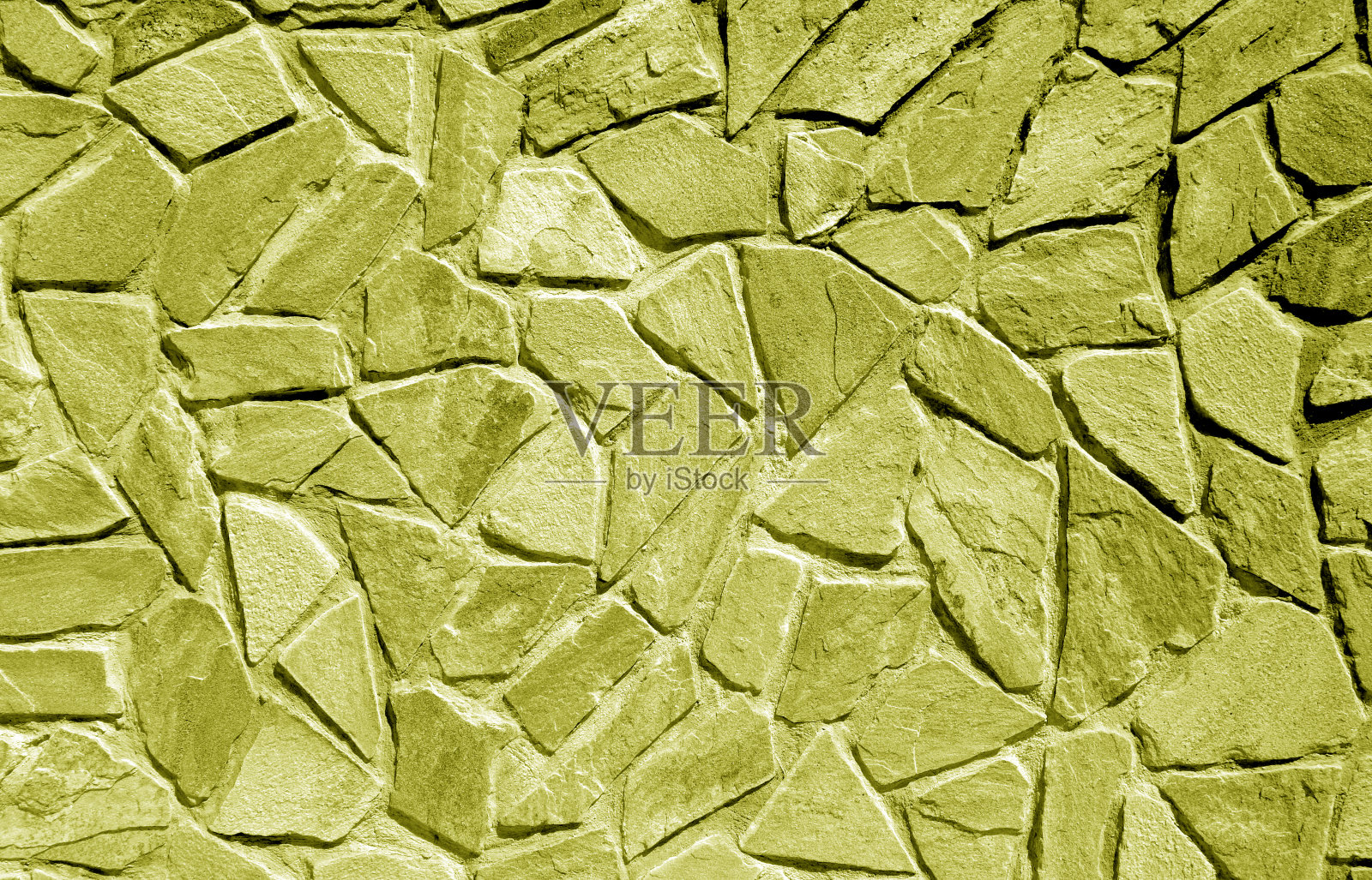 用黄色调的旧石头砌成的墙。照片摄影图片