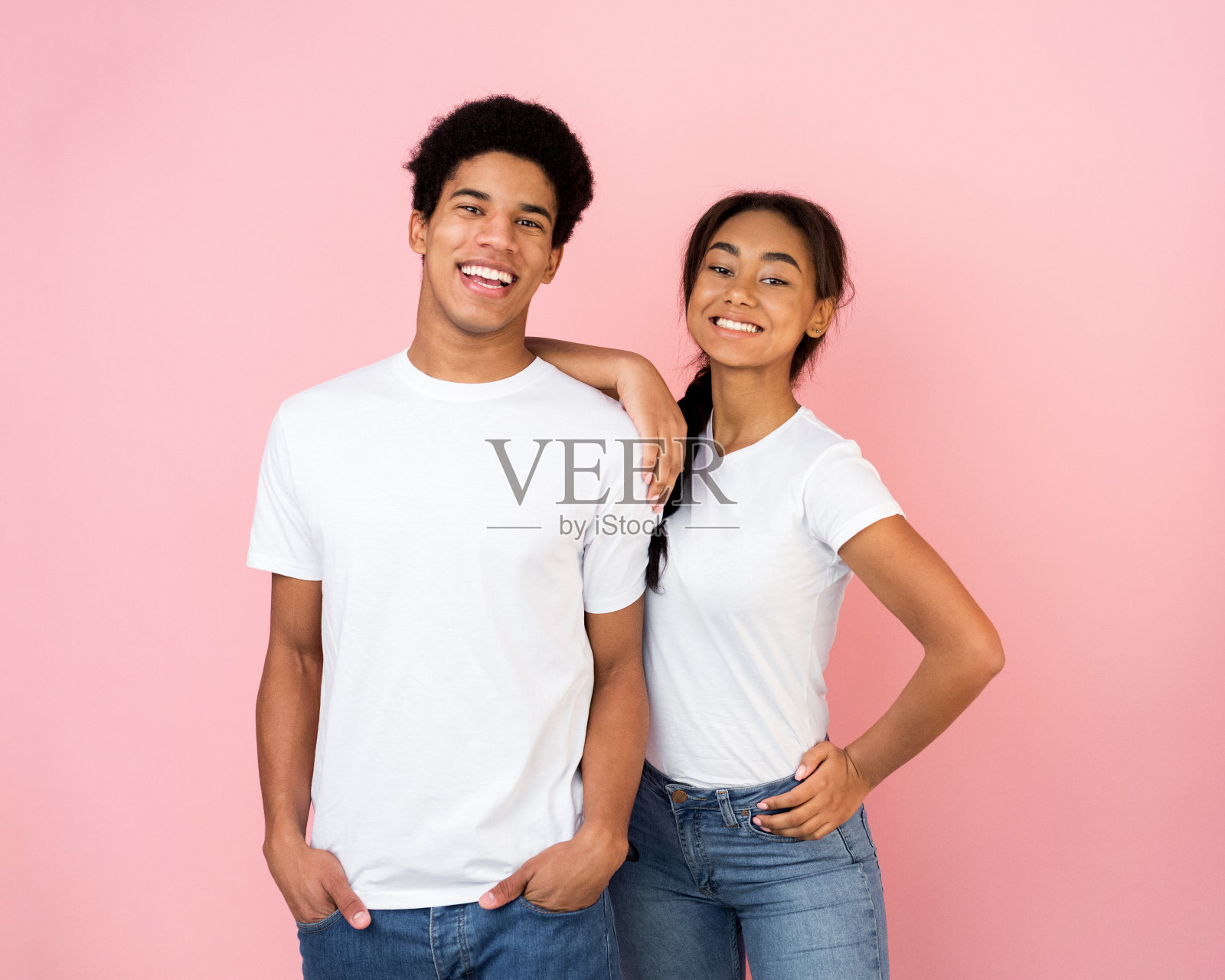 一对激动的黑人夫妇在粉红色的工作室背景上摆姿势照片摄影图片