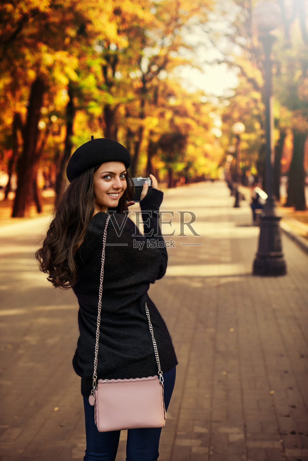 拿着复古相机拍照的女人照片摄影图片