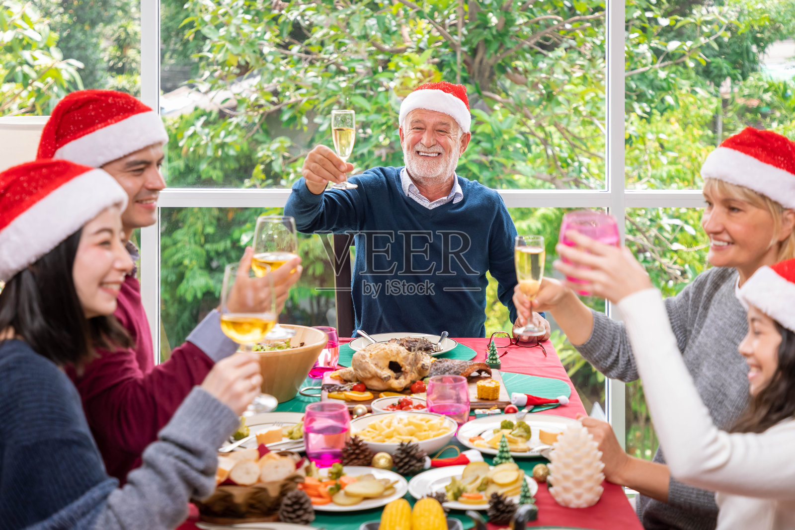 多代同堂的大家庭欢聚一堂共进晚餐，共同庆祝圣诞佳节照片摄影图片