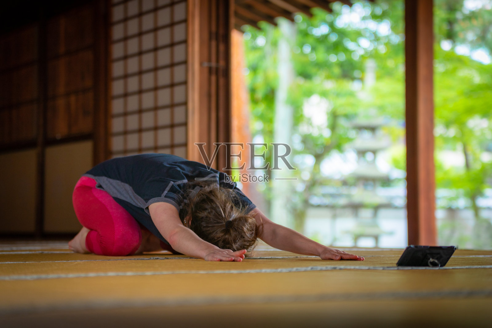 白人女性喜欢在寺庙里用智能手机练瑜伽照片摄影图片