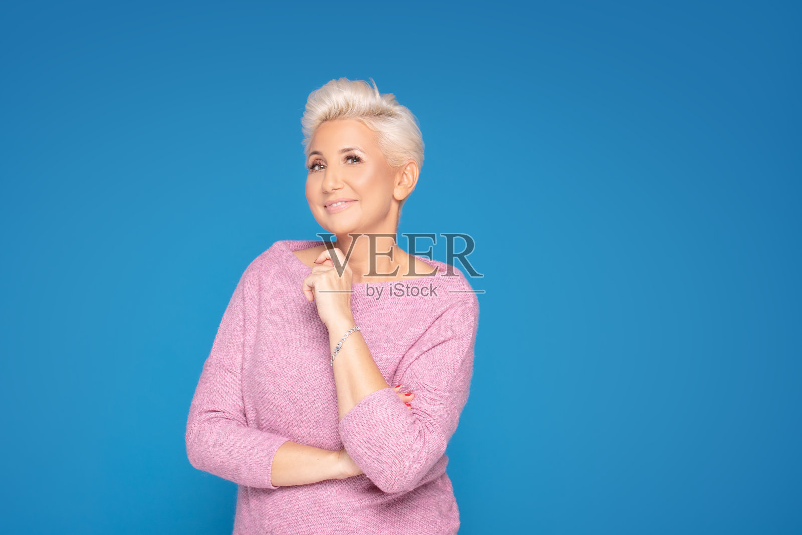 一个中年女人在摄影棚里摆姿势。照片摄影图片