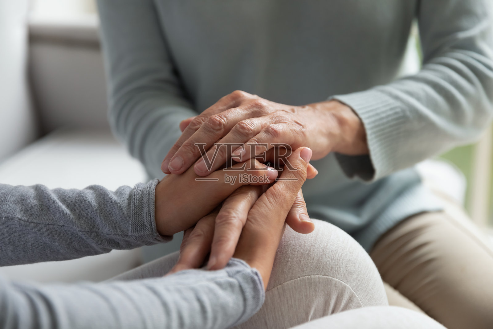 拉近年轻女士和中年妇女的手。照片摄影图片