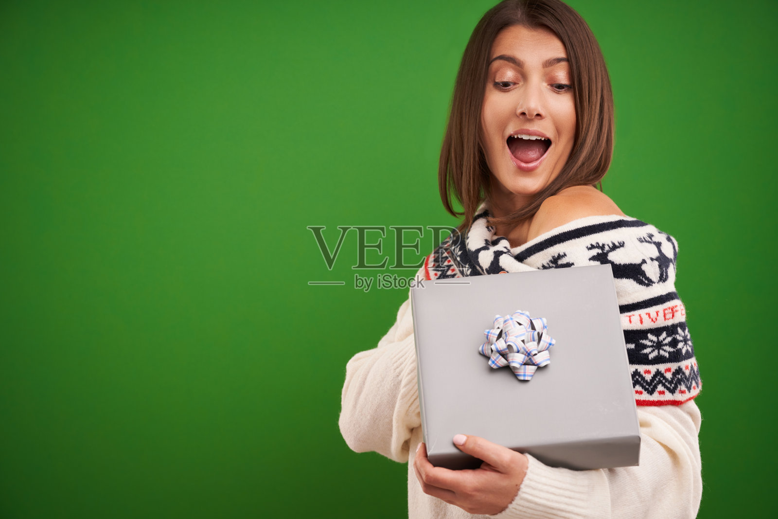 成人快乐的女人与圣诞礼物在绿色的背景照片摄影图片