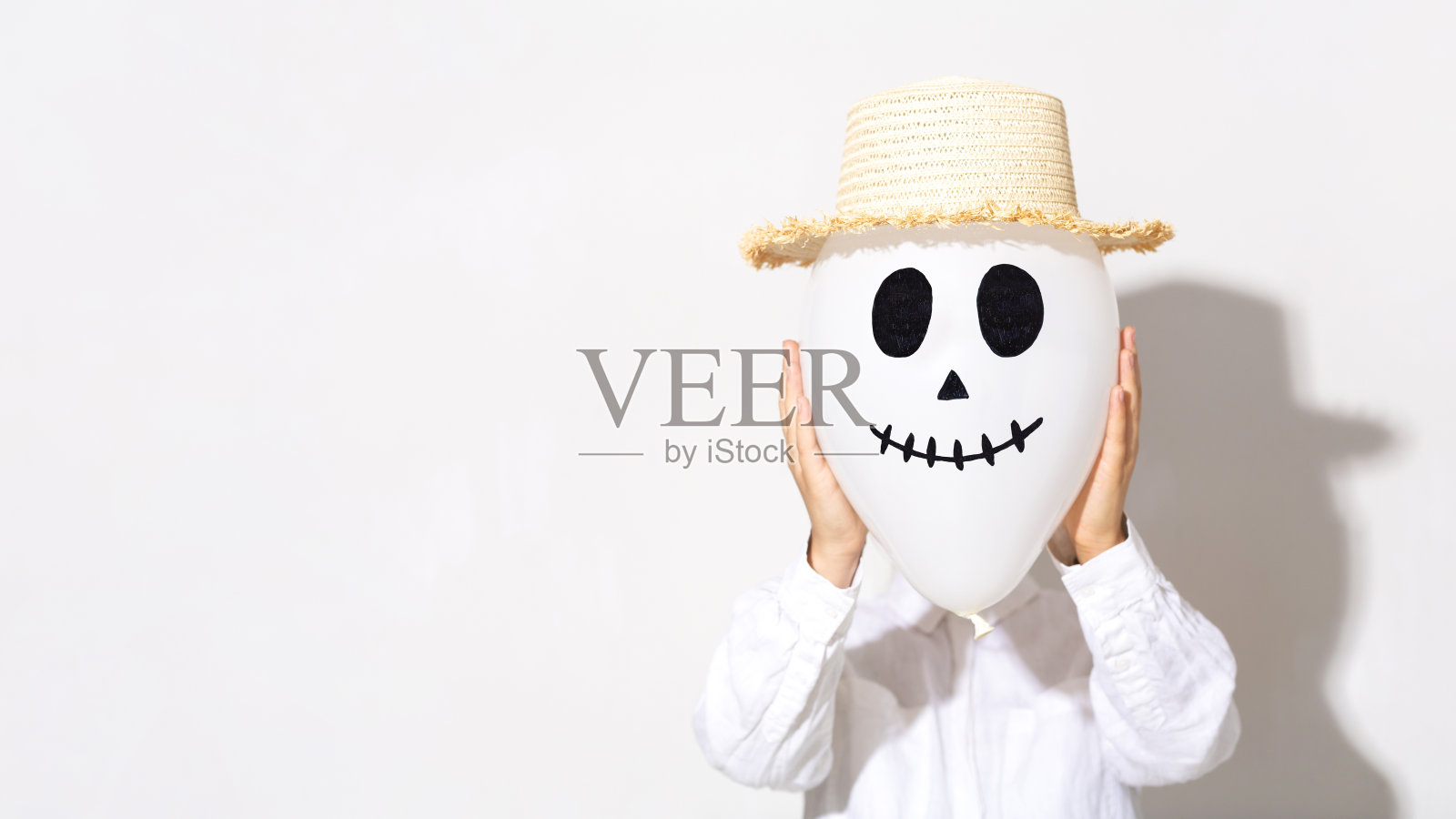穿着白色衬衫，头戴幽灵气球的女人照片摄影图片