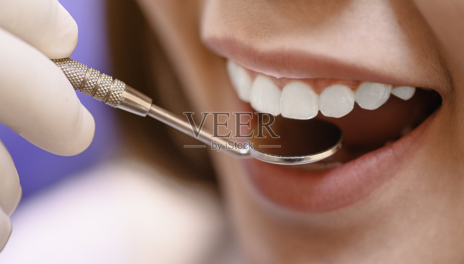 牙科医生在诊所检查病人的牙齿，为更好的牙齿健康和一个灿烂的微笑。照片摄影图片