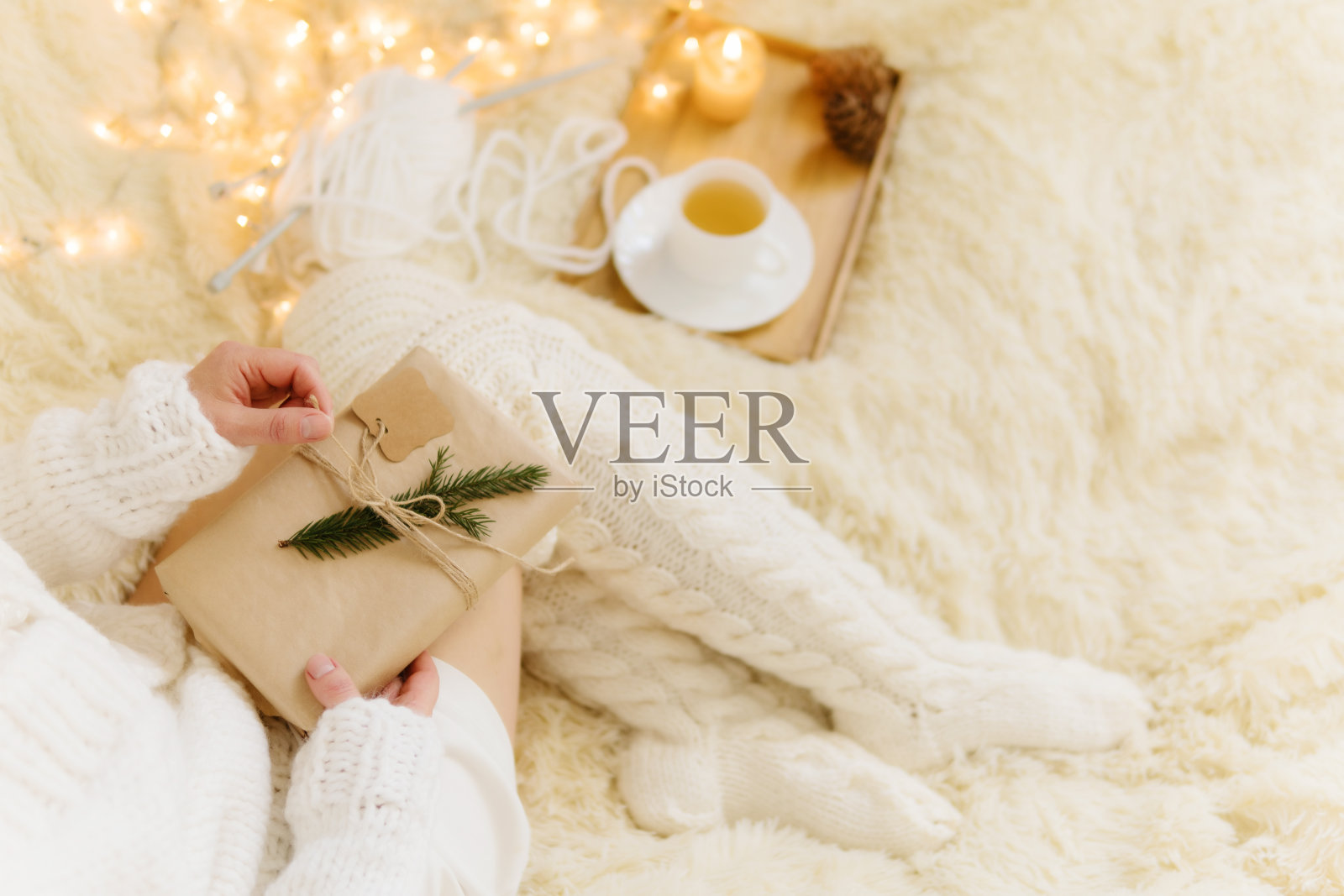 在舒适的房间里拿着礼物的女人。圣诞快乐!照片摄影图片