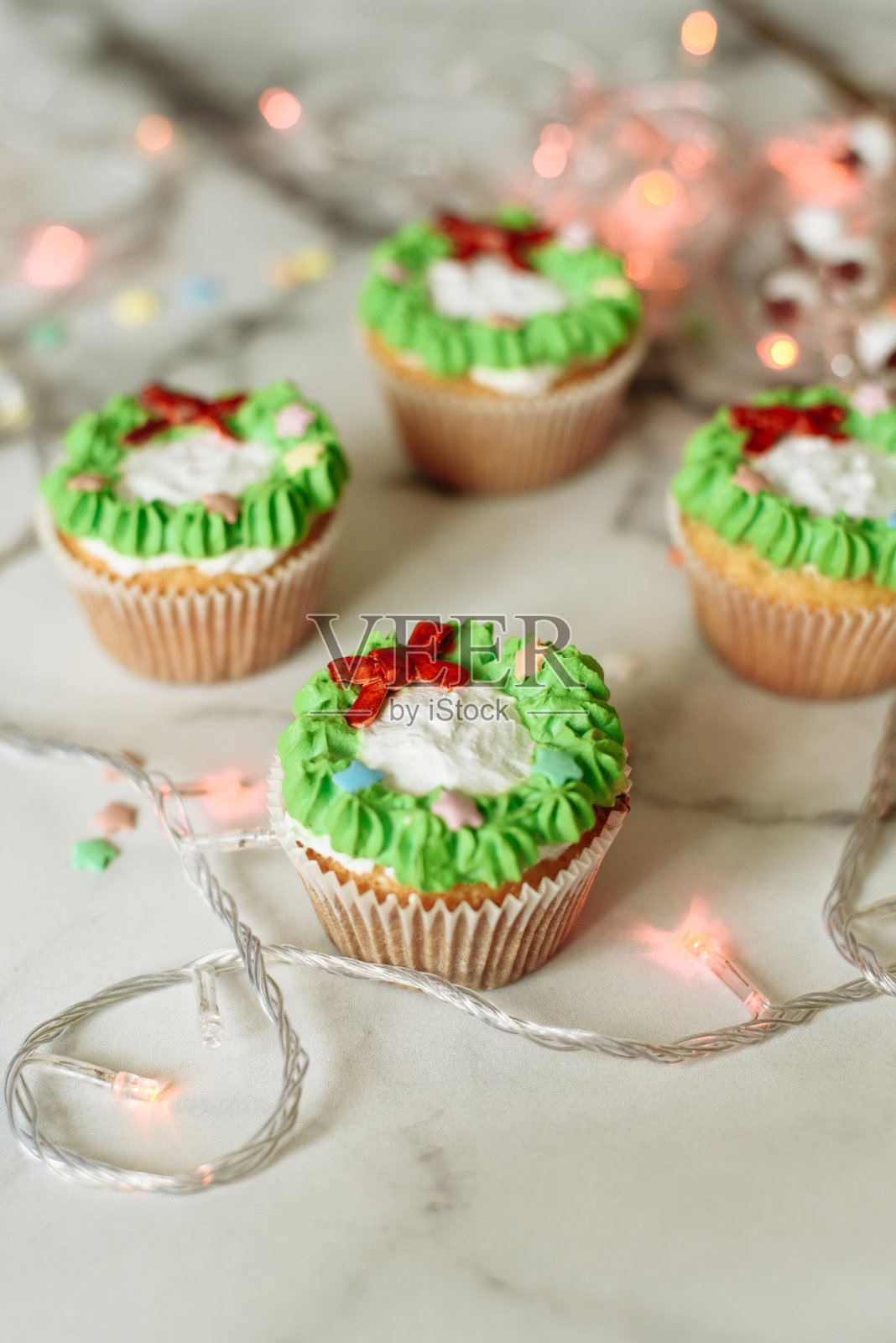 大理石桌上放着新年糖果。用乳香和奶油装饰的圣诞纸杯蛋糕照片摄影图片