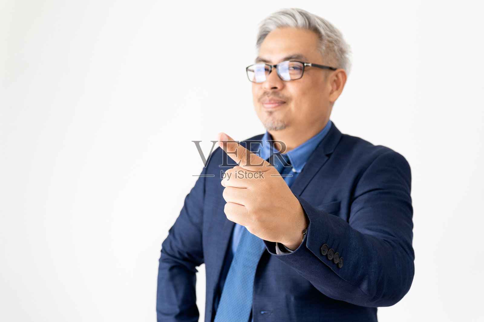肖像自信的亚洲商人戴眼镜和蓝色西装指向与手在白色背景照片摄影图片