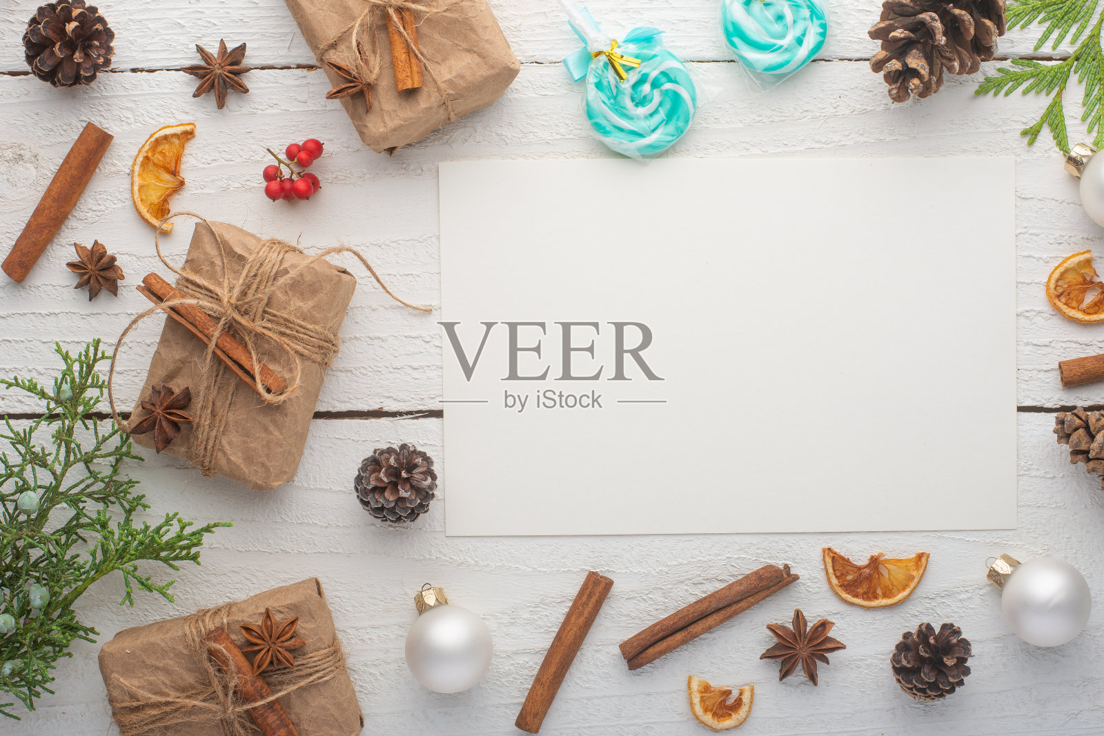 圣诞帧。明信片与圣诞树枝和礼物，在白色木制背景。照片摄影图片