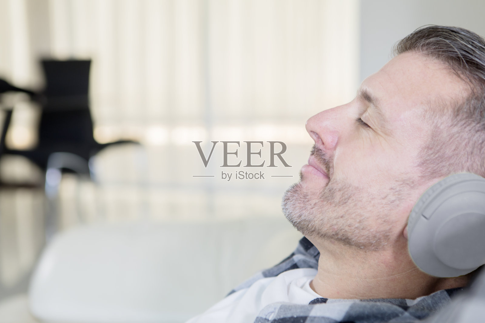 一个坐在沙发上欣赏音乐的白人照片摄影图片