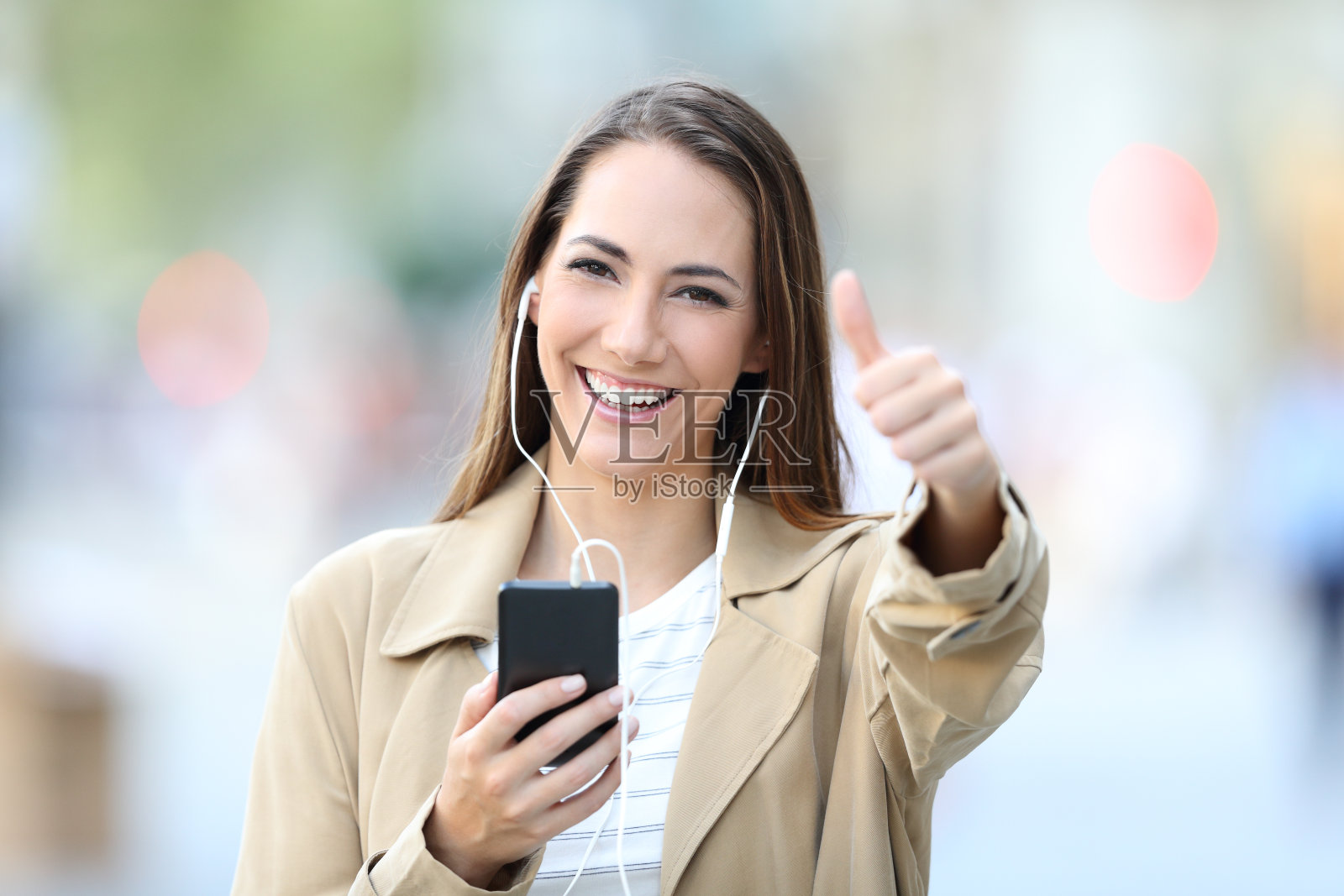 快乐的女孩边听音乐边竖起大拇指摆姿势照片摄影图片