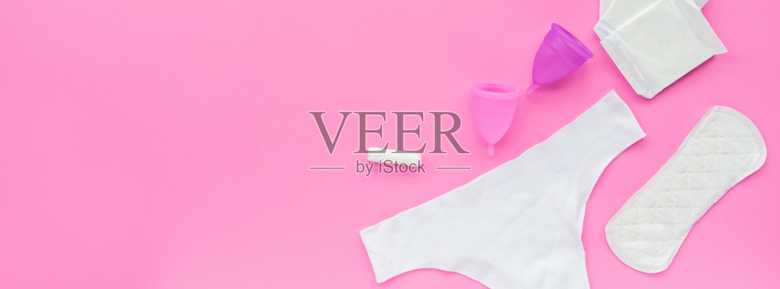 带包的月经杯，卫生巾，卫生棉条，粉色背景的白色内裤。替代女性卫生用品。女性健康概念照片摄影图片