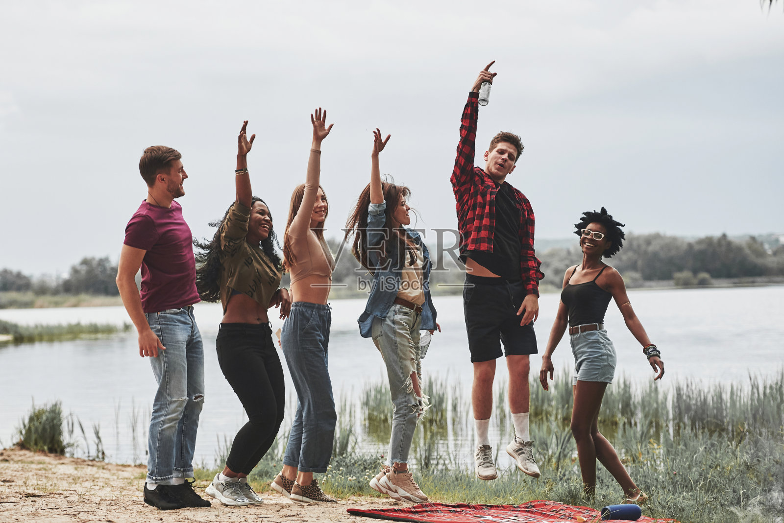 充满了能量。一群人在海滩上野餐。朋友们在周末玩得很开心照片摄影图片