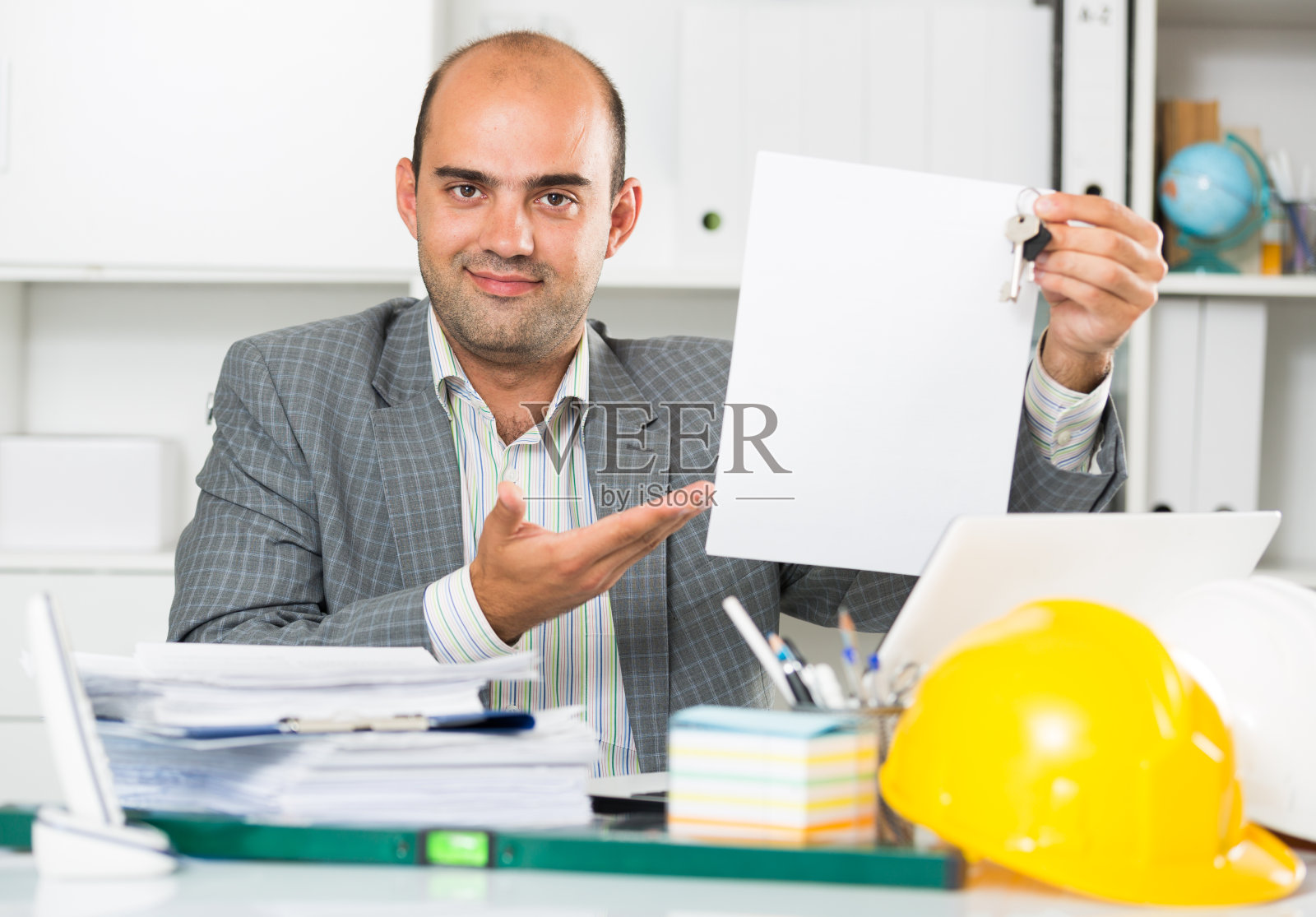 建筑师在办公室，手里拿着钥匙照片摄影图片