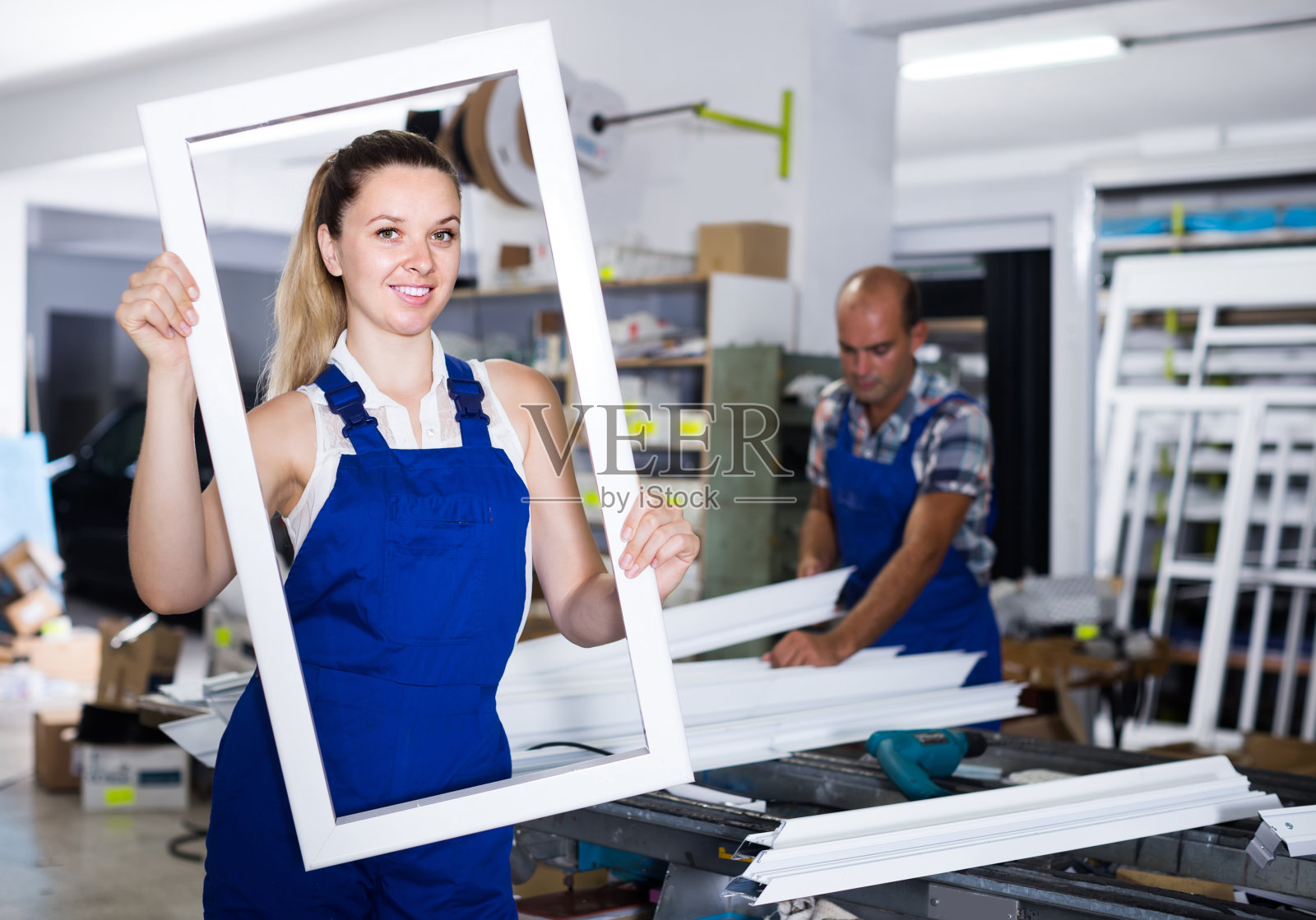 女孩在工作穿着窗框从PVC型材站在工作场所照片摄影图片