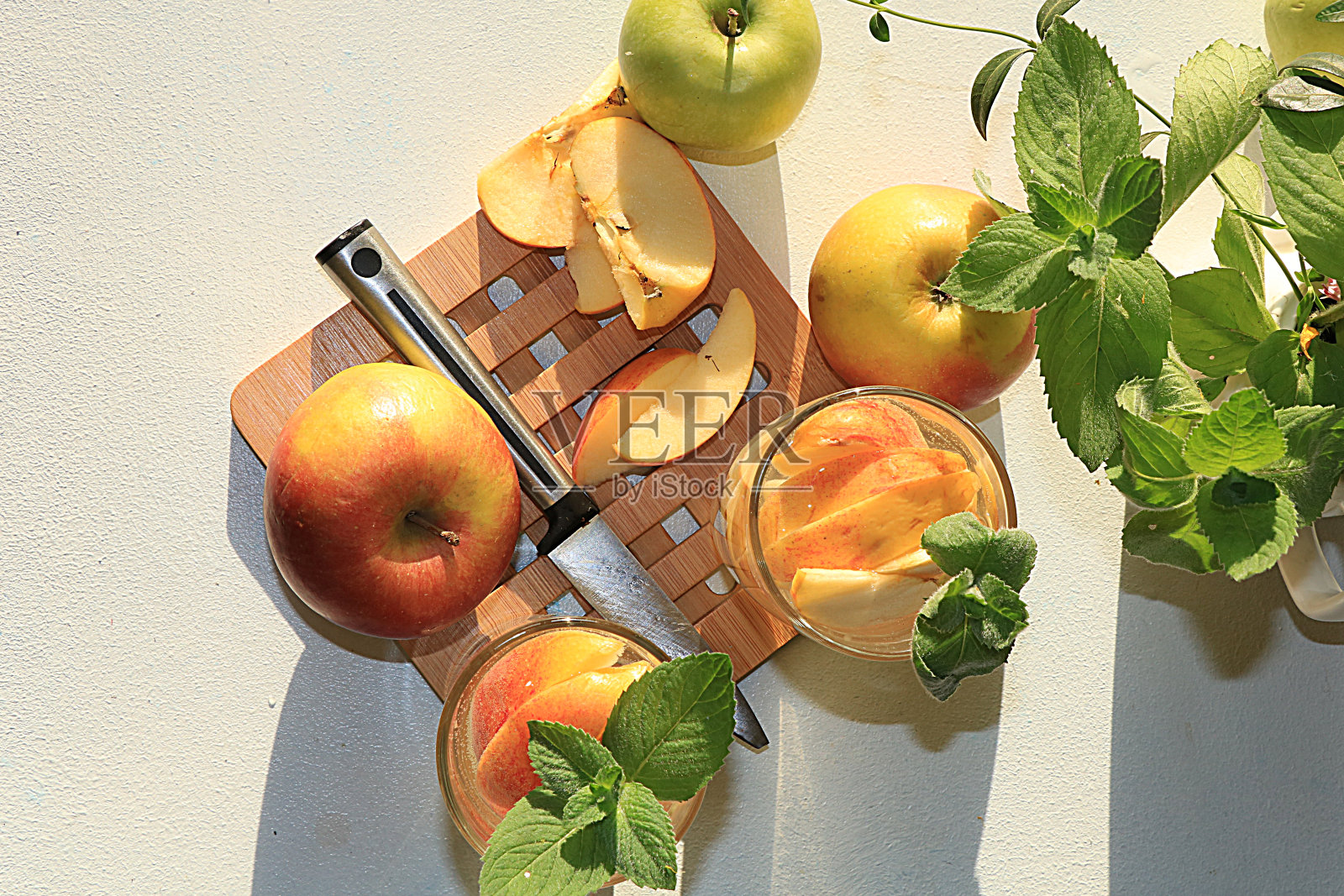 苹果酒，果汁或水果饮料在一个杯子在阳光充足的桌子上。饮食和减肥的概念。苹果有助于清洁身体和减肥。照片摄影图片