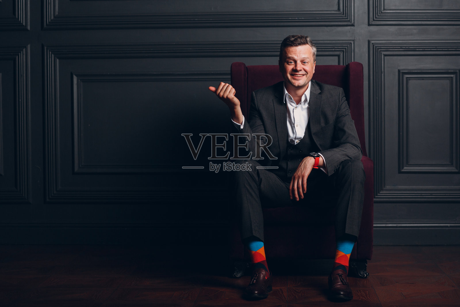 一个穿着灰色西装的商人的肖像。商业和成功的概念与复制空间和手势照片摄影图片