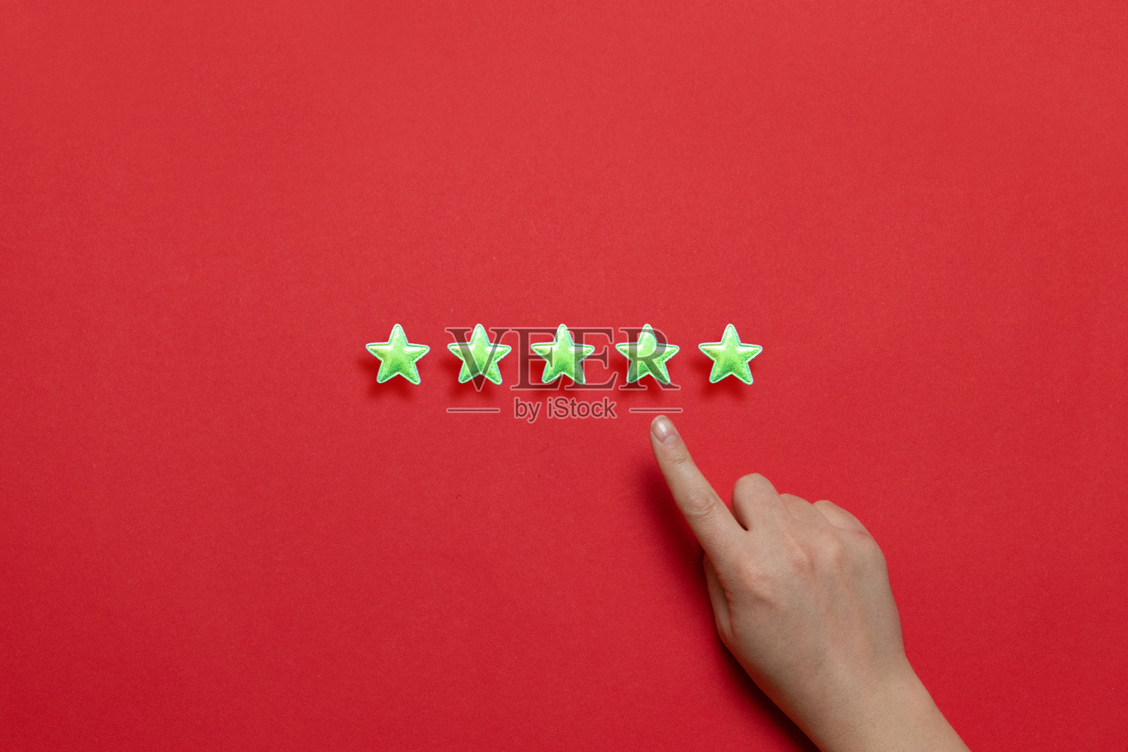 提供的服务的最佳评级。明亮的黄色星星和一只女性的食指在红色的背景上照片摄影图片