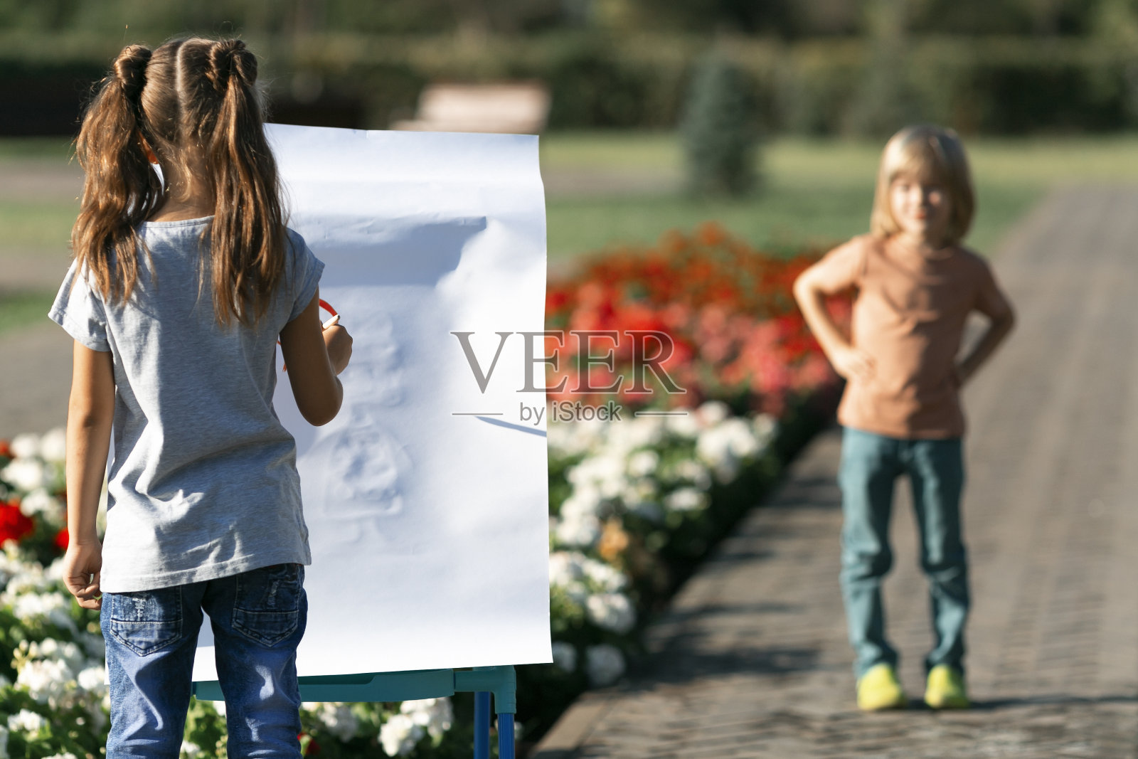 一个小女孩画她的弟弟为模特照片摄影图片