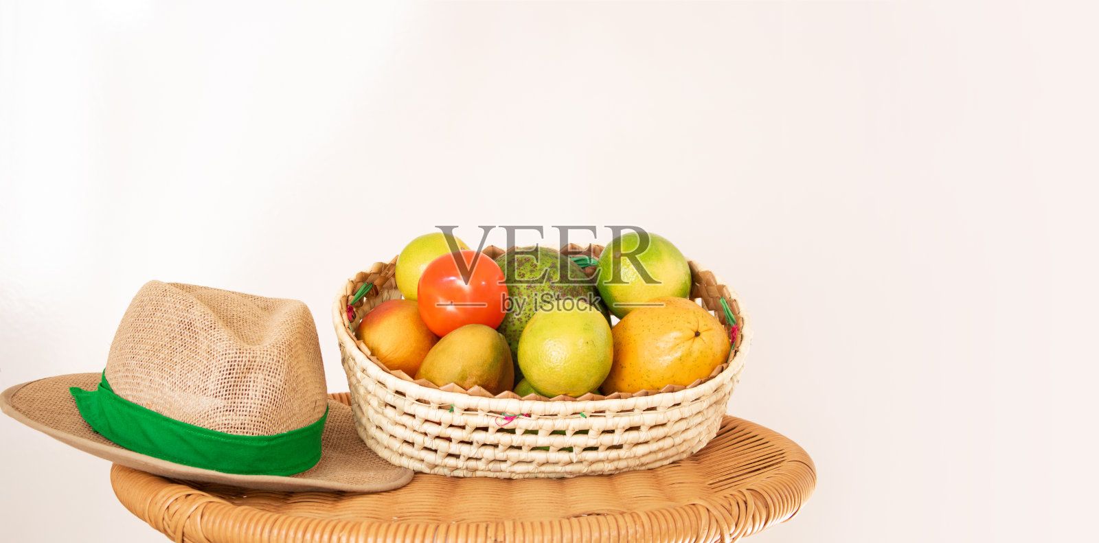 桌子上有一篮子水果和草帽。农业概念的形象。照片摄影图片