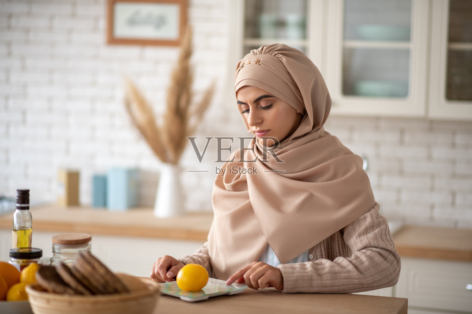 正在计算卡路里的年轻穆斯林女孩照片摄影图片