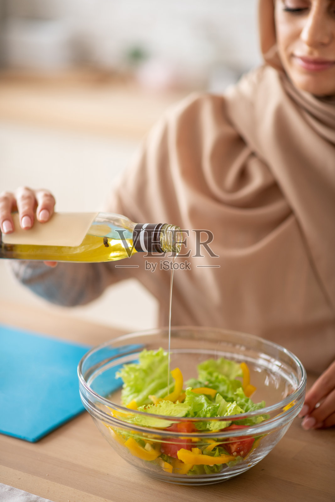 漂亮的女人在烹饪时使用沙拉酱照片摄影图片