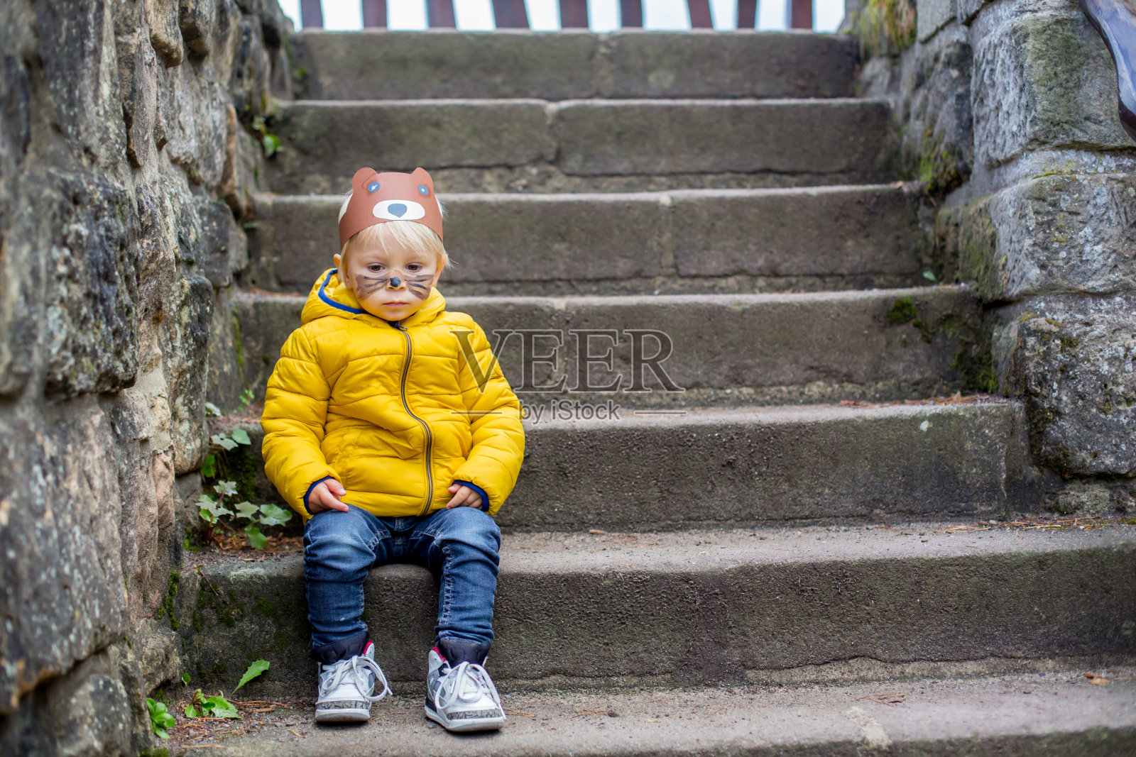 可爱的金发小孩，带着熊面具和彩绘的脸照片摄影图片