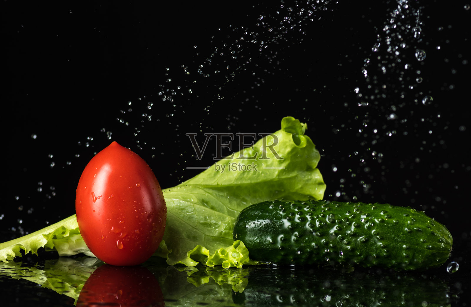 新鲜蔬菜与水滴在黑色背景，pidor，黄瓜，甜椒，洋葱，绿色蔬菜照片摄影图片