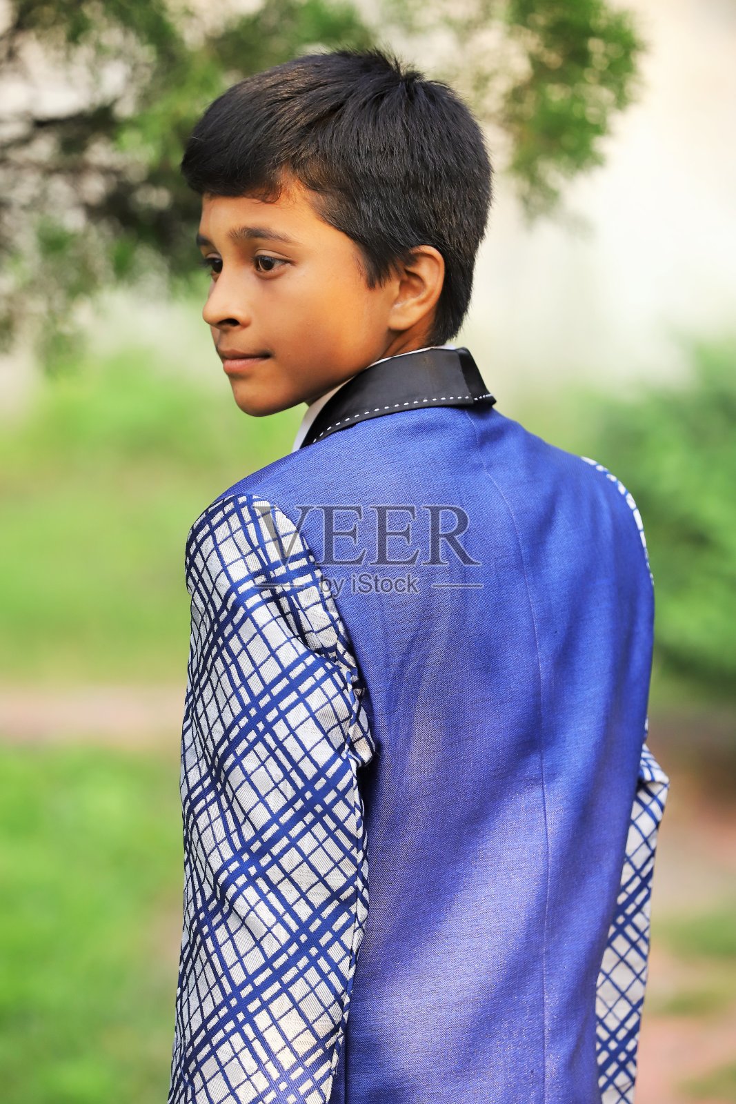 印度尼西亚男孩在户外摆姿势穿着西装。照片摄影图片