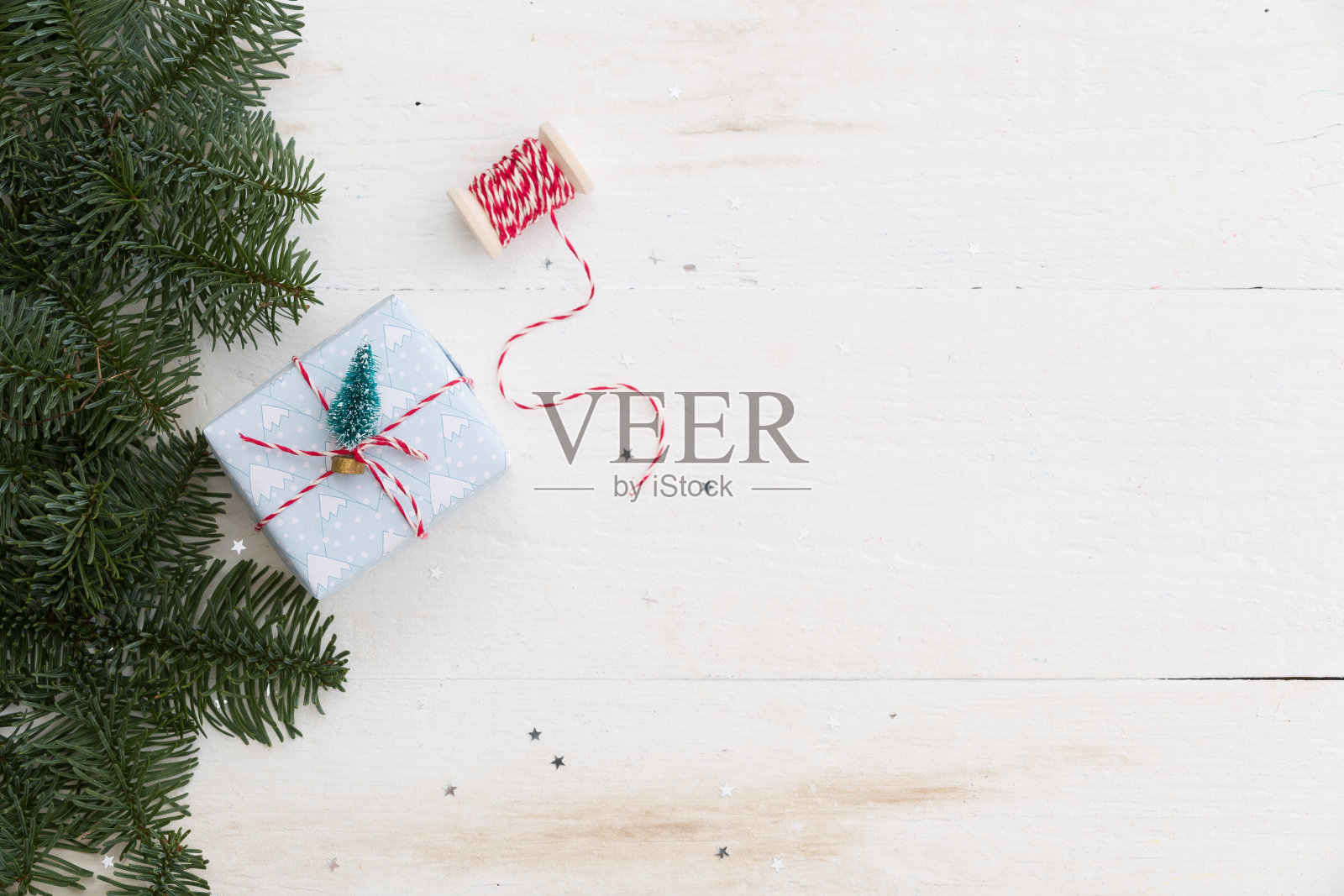 在白色木桌上包装圣诞礼品盒。顶部视图与复制空间照片摄影图片