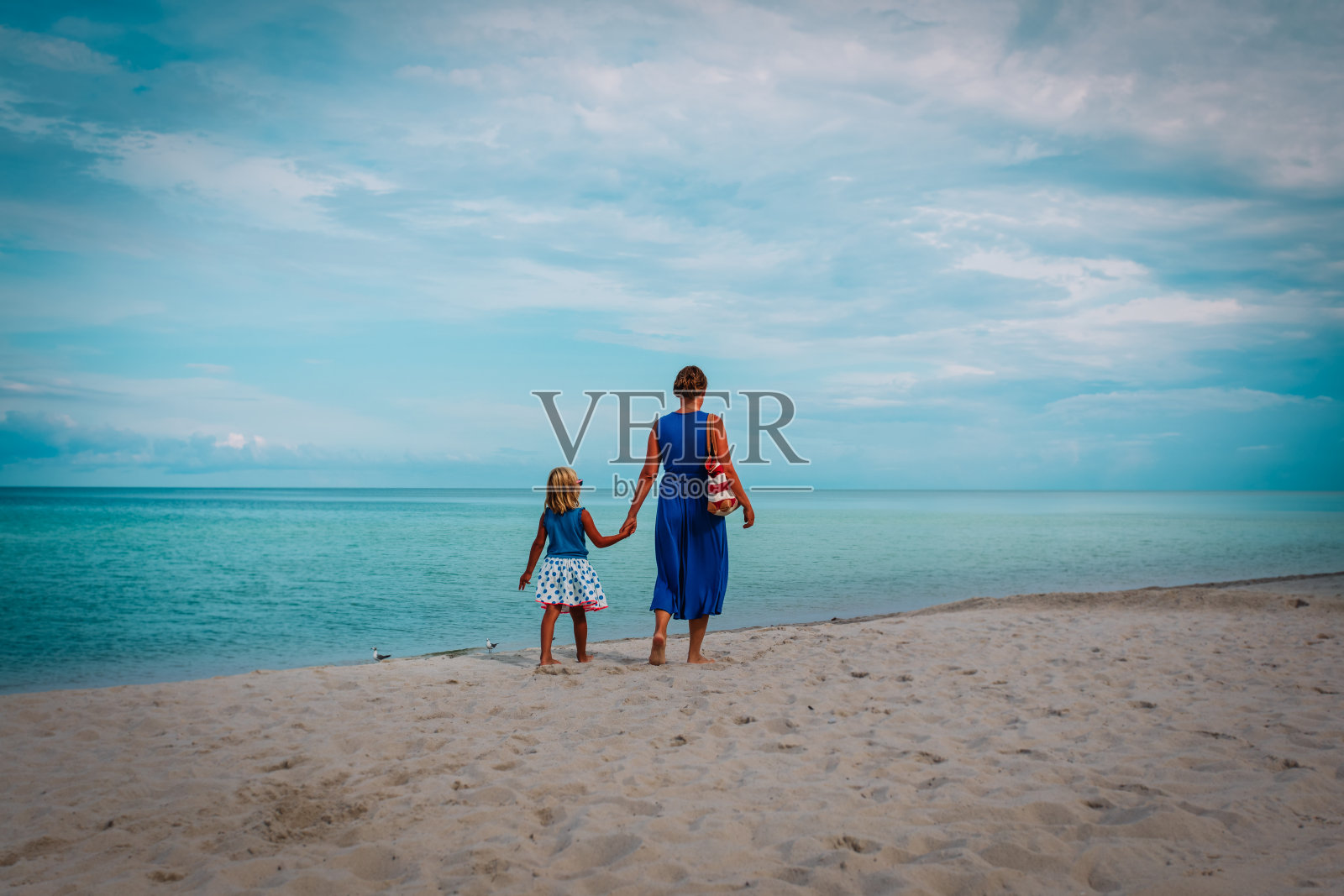 妈妈和小女儿在海滩上散步照片摄影图片