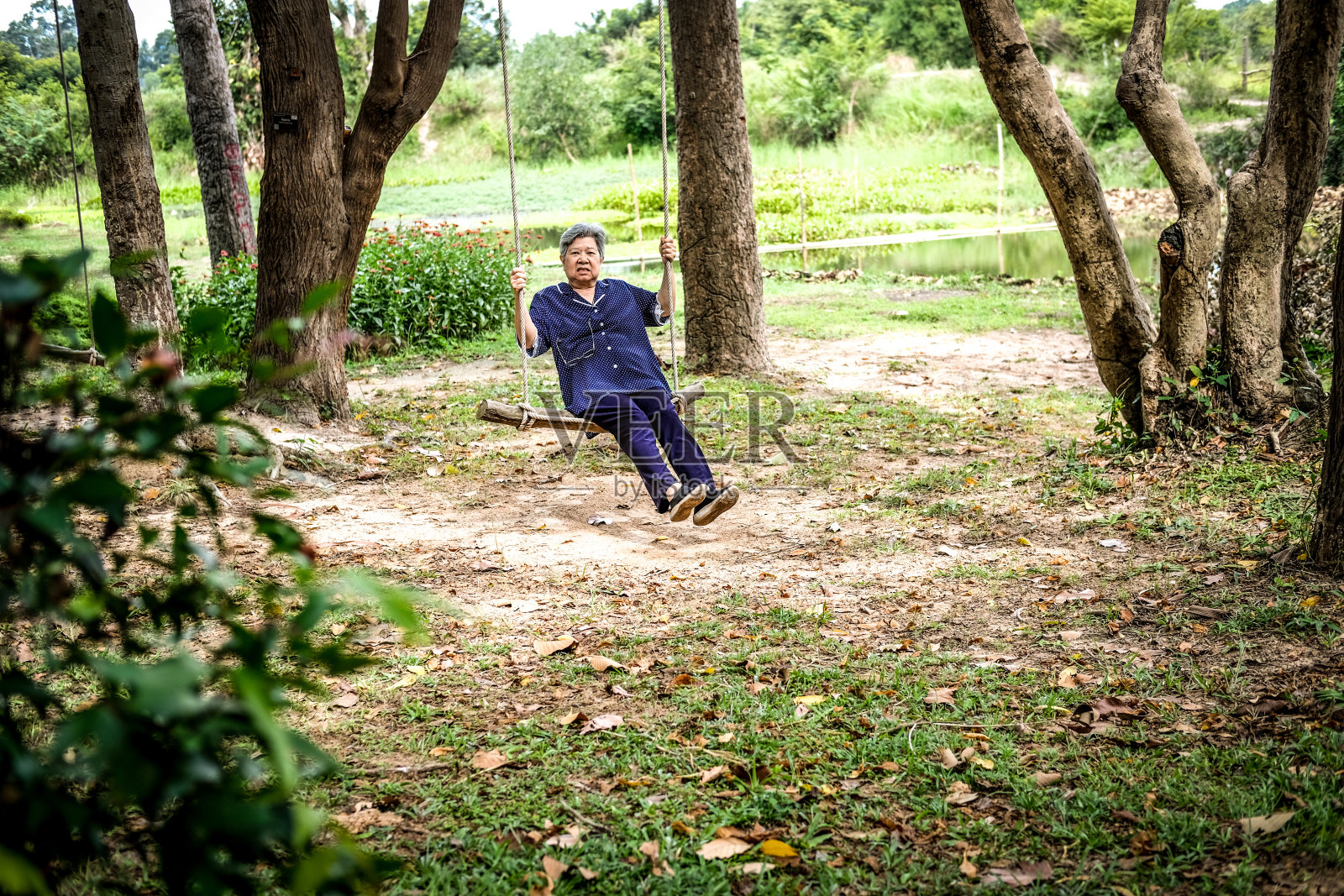 老女人坐在秋千上照片摄影图片