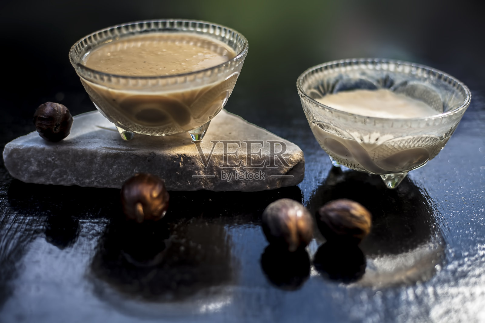 肉豆蔻香料面膜在黑色的表面由一些凝乳与肉豆蔻或贾法尔粉混合在一个玻璃碗。加生香料和凝乳。水平最高。照片摄影图片