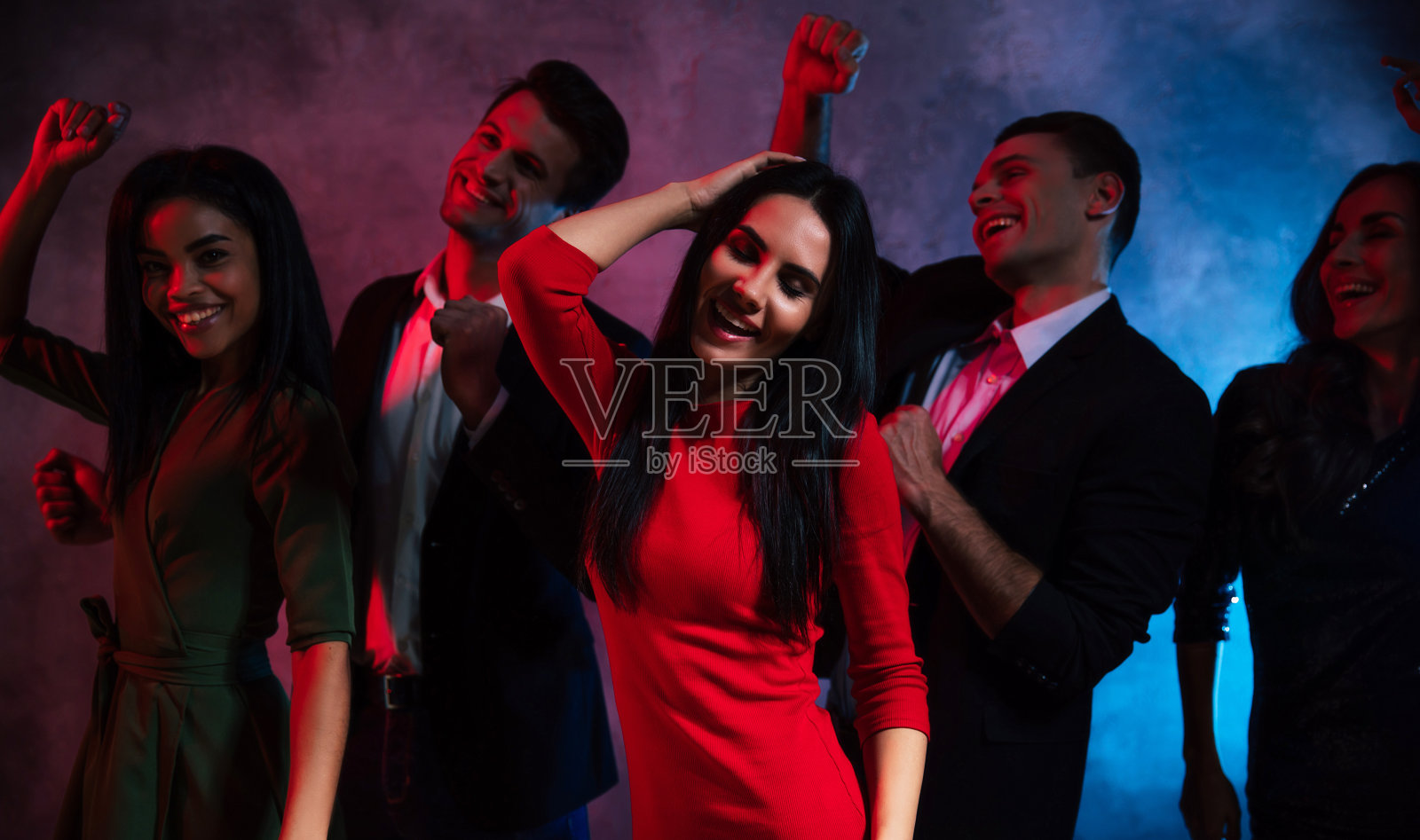 在俱乐部度过一晚。在俱乐部的聚会上，一群五岁的年轻人穿着礼服和西装，脸上洋溢着极其快乐的表情，一起跳舞。照片摄影图片