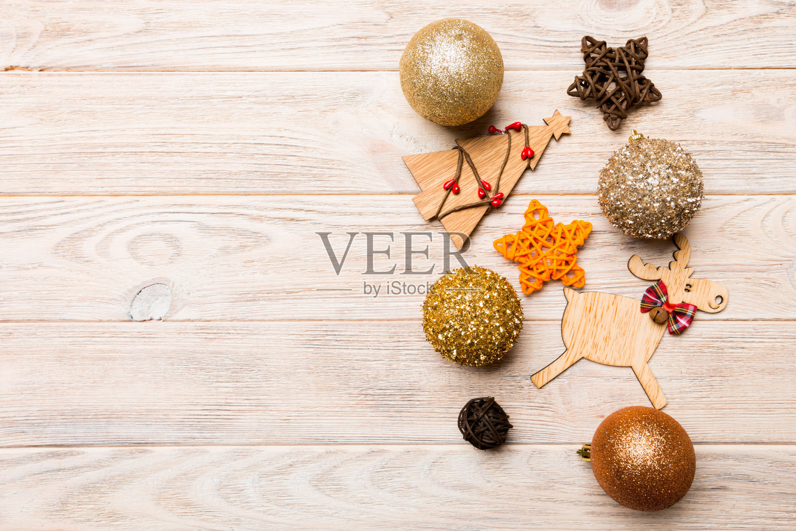 由装饰物、驯鹿和其他木制背景装饰而成的新年作品。圣诞时间概念与空空间为您的设计照片摄影图片