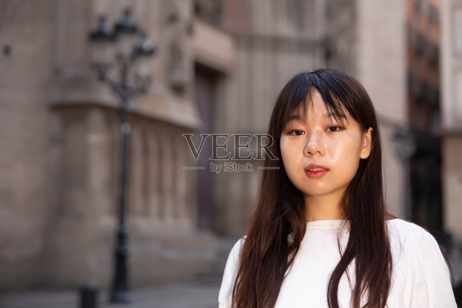 一幅兴高采烈的中国长发女子站在城市街道上的肖像照片摄影图片