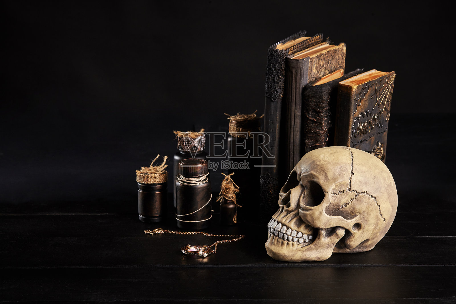 一个有牙齿的人类头骨模型放在一张黑色木头桌子上，黑色的背景。医学或者万圣节恐怖概念特写镜头照片摄影图片