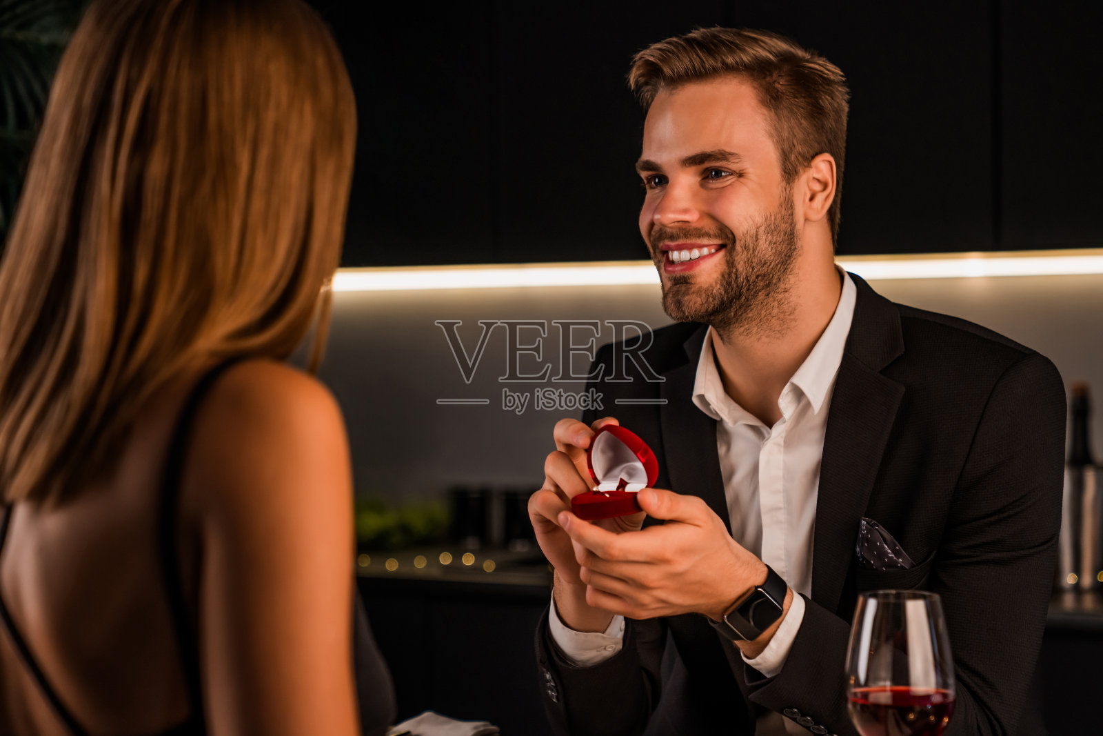 一名男子在家里吃浪漫晚餐时微笑着向女友求婚照片摄影图片