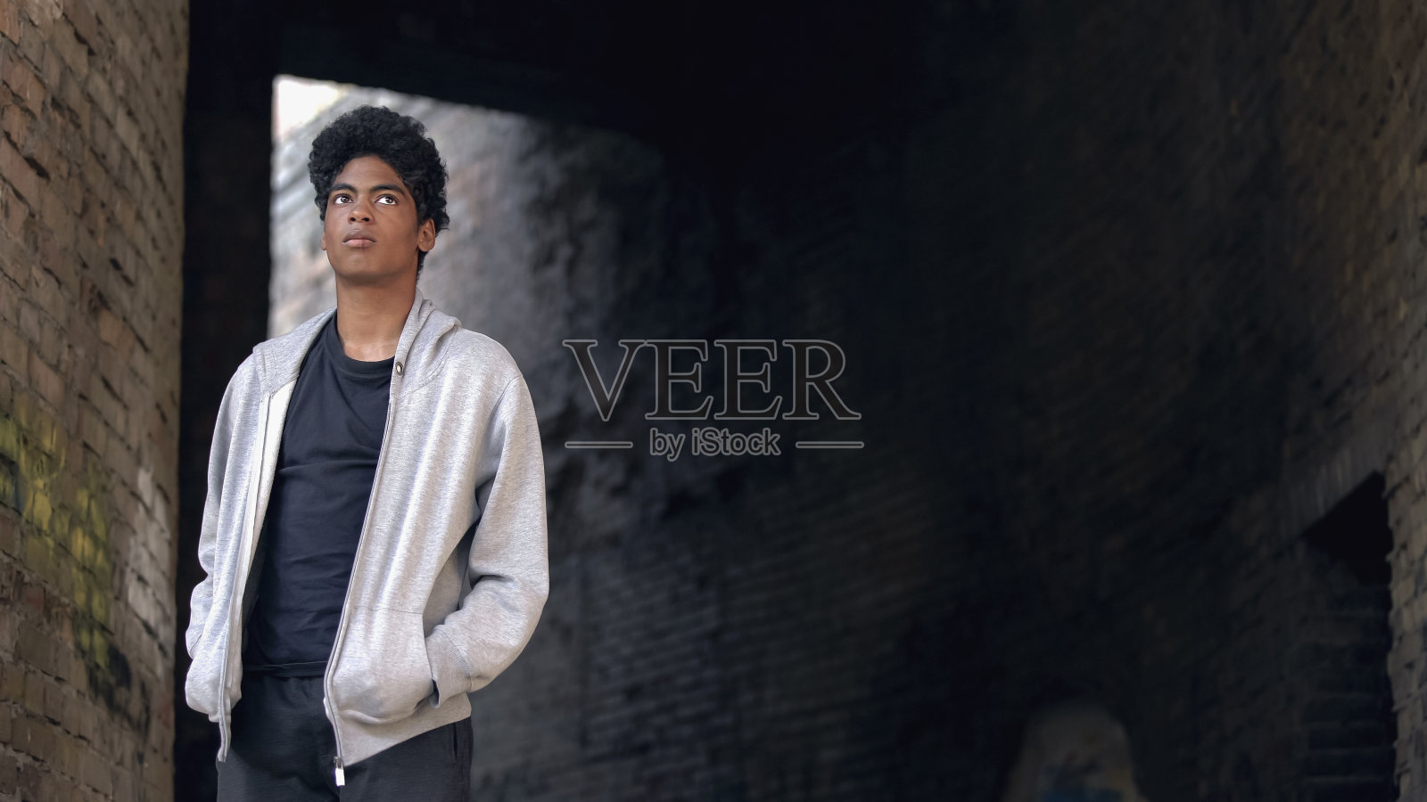 孤独的非裔美国男人独自走在废弃的城市建筑旁照片摄影图片