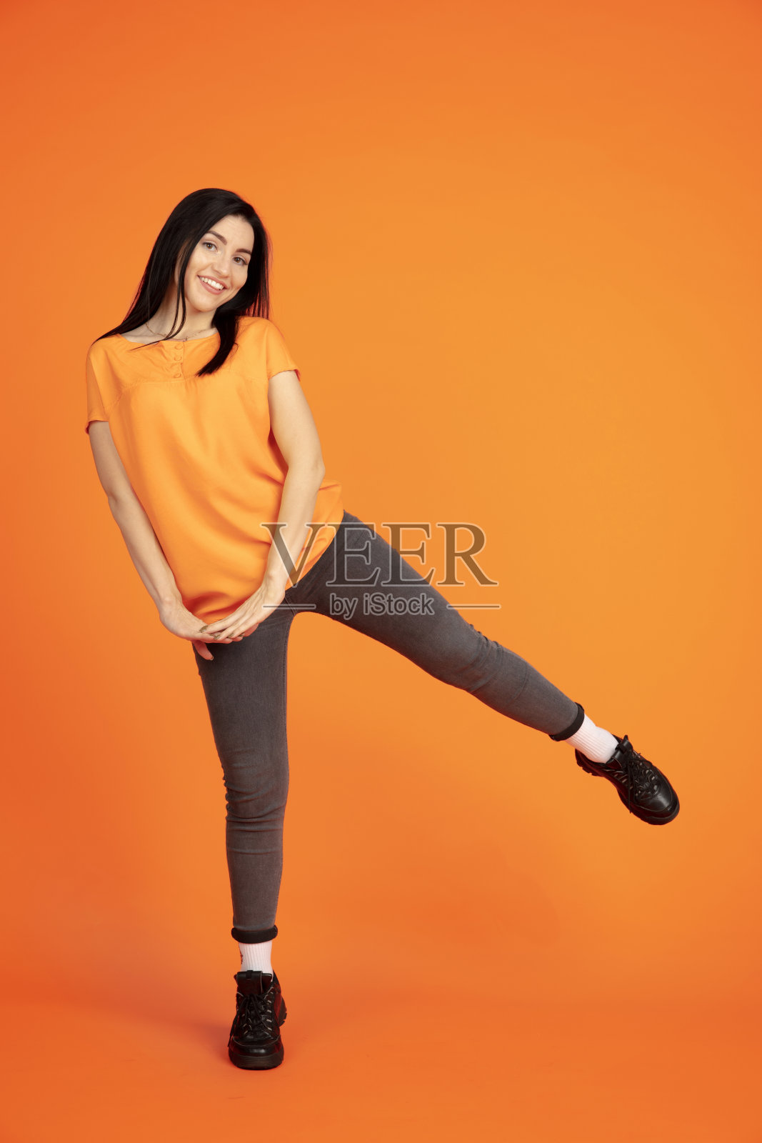 橙色背景上的白人年轻女子肖像照片摄影图片