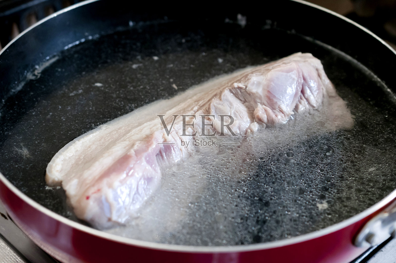 煮猪肉，煮猪肉是为了准备食物。照片摄影图片