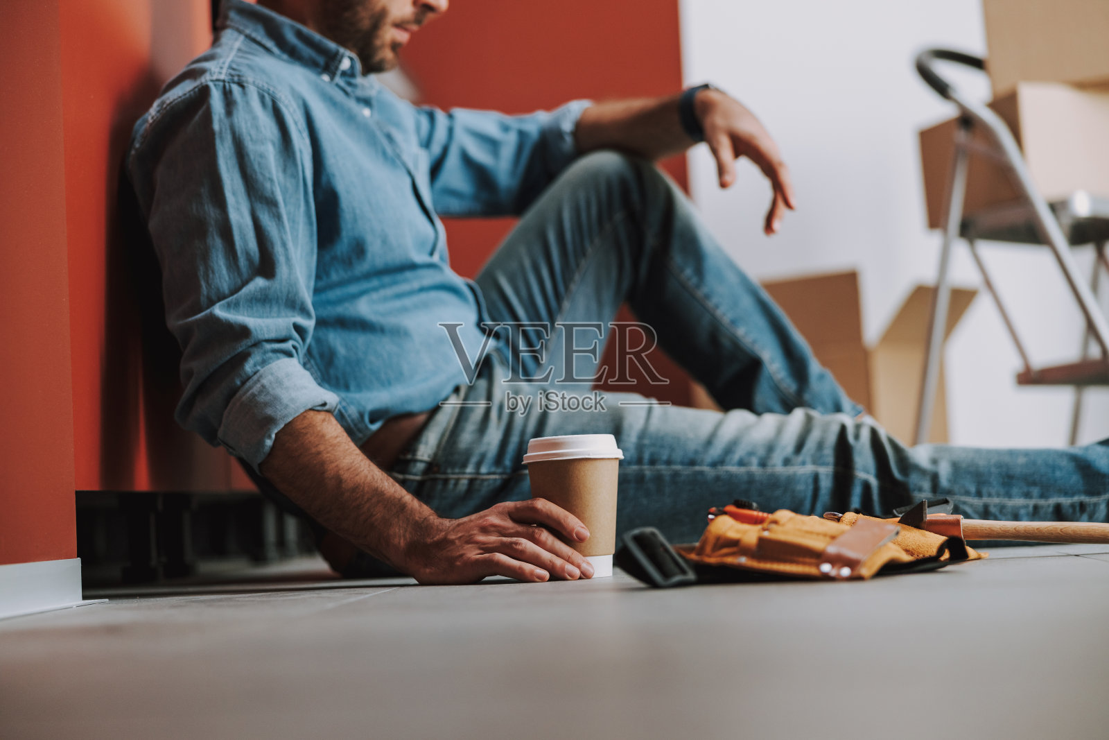 疲惫的修理工拿着咖啡在地板上的照片照片摄影图片