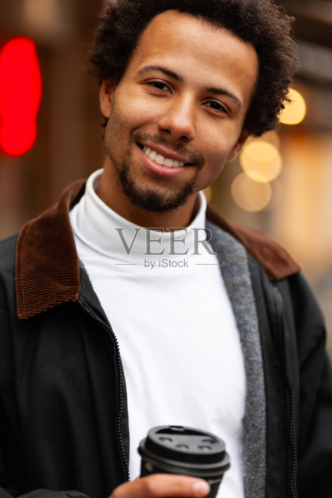 一幅迷人的年轻非洲男子在户外喝咖啡的肖像照片摄影图片