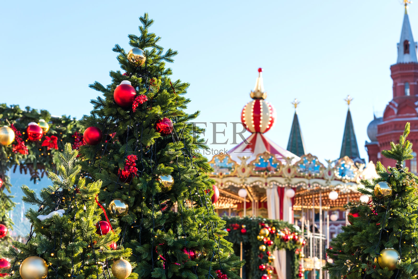 莫斯科圣诞节之旅。在历史博物馆前的马涅什尼亚广场上，被照亮的新年树和旋转木马照片摄影图片