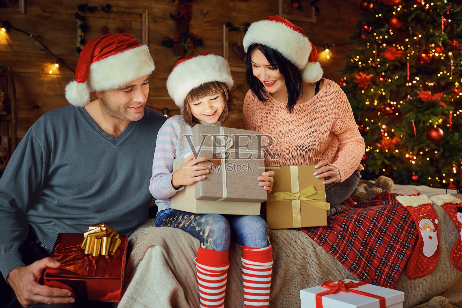 圣诞节时，家人在房间里给女儿一份礼物。照片摄影图片