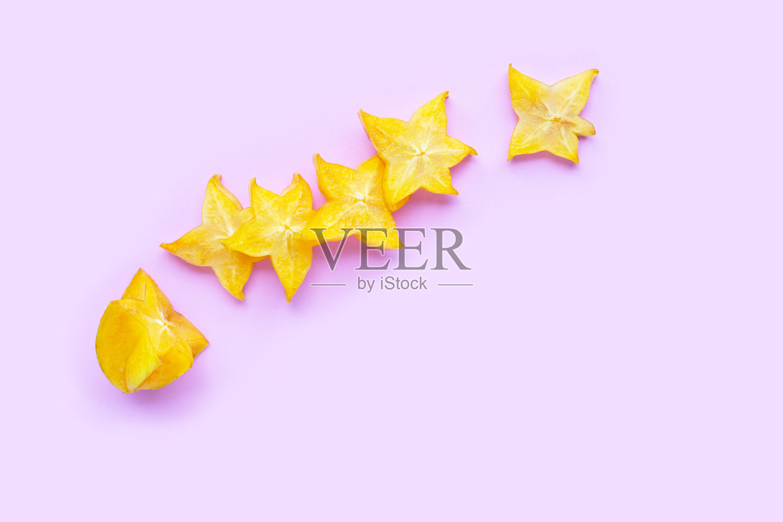 粉红色背景上的成熟杨桃。照片摄影图片