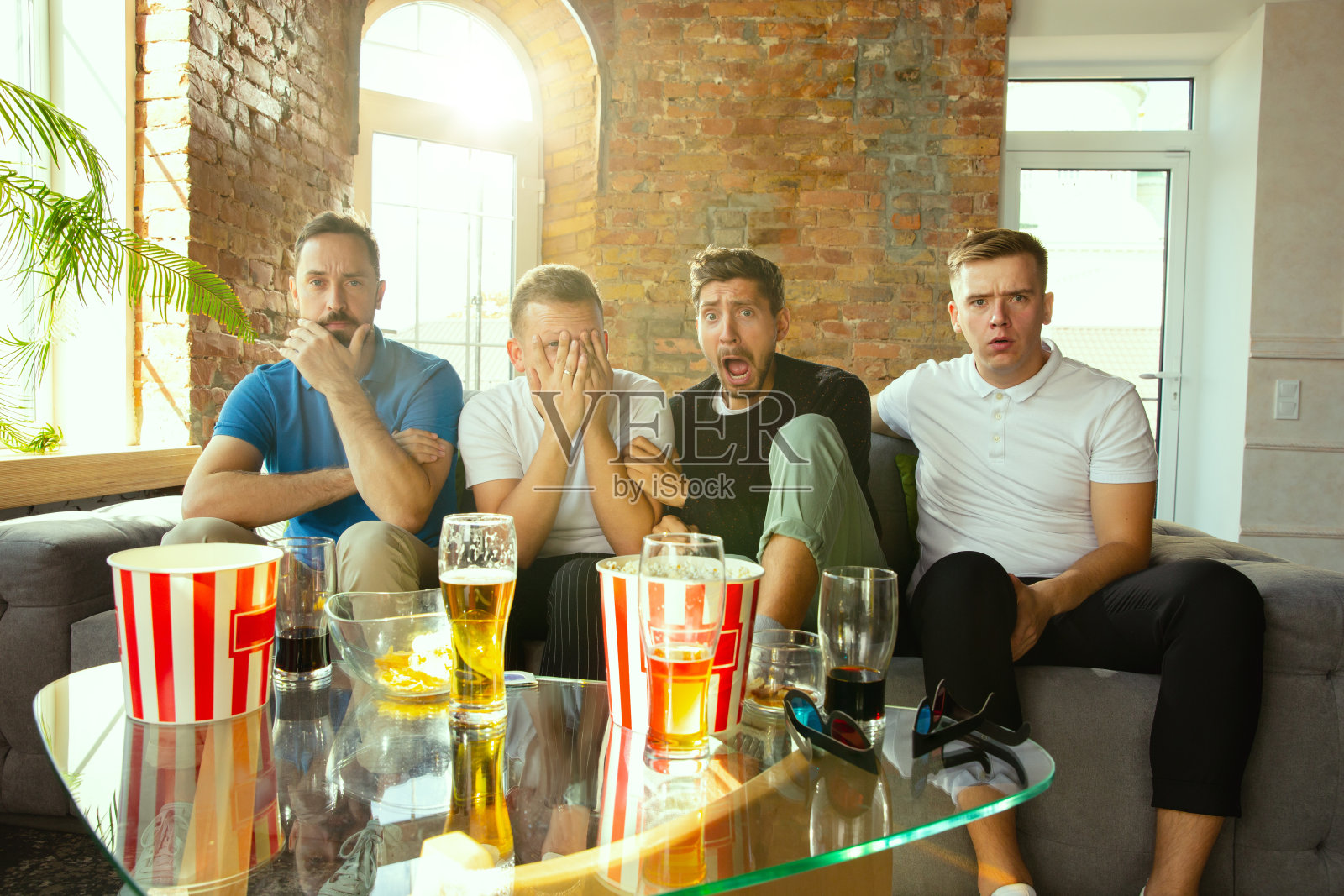 一群朋友在家看电视上的足球比赛照片摄影图片